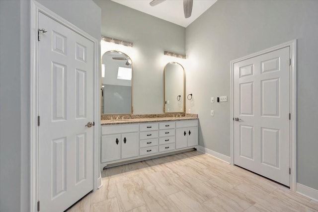 bathroom featuring double vanity, baseboards, a ceiling fan, and a sink