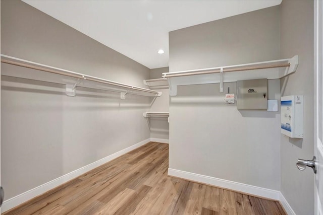 walk in closet with wood finished floors