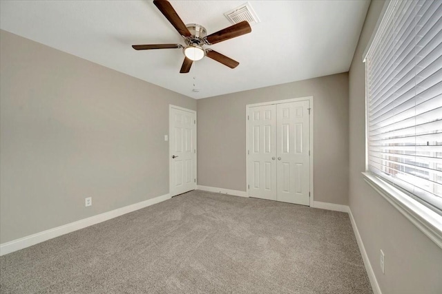 unfurnished bedroom with visible vents, baseboards, light colored carpet, a closet, and a ceiling fan