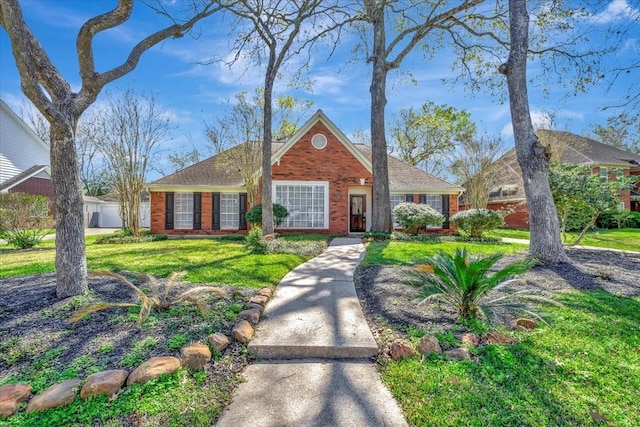 view of front of house featuring brick siding and a front yard