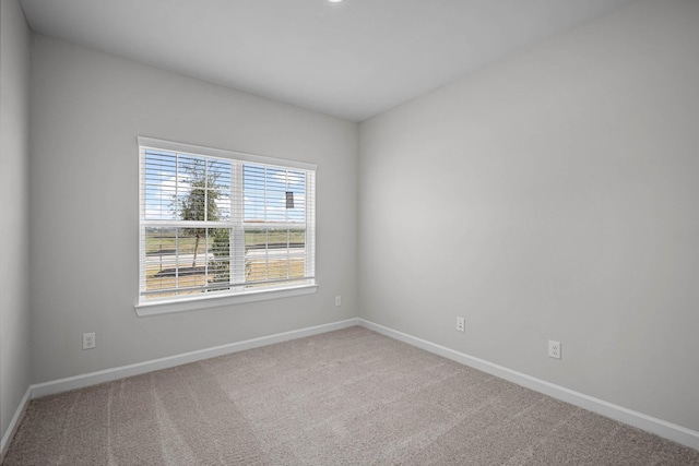 empty room featuring carpet and baseboards