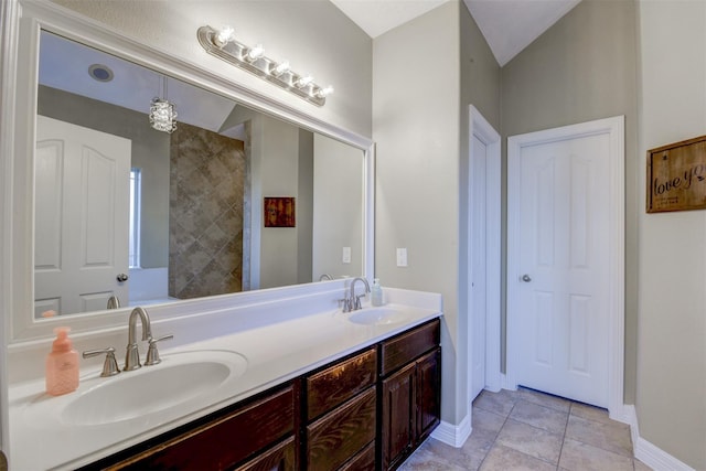 full bath featuring tile patterned flooring, double vanity, baseboards, and a sink