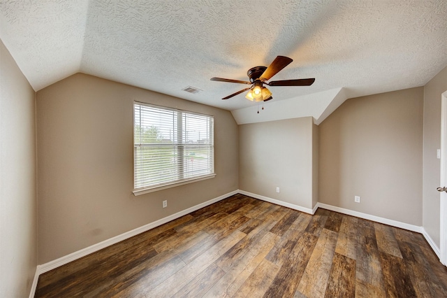 unfurnished room with vaulted ceiling, wood-type flooring, baseboards, visible vents, and a ceiling fan