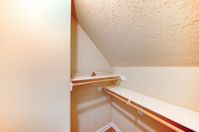walk in closet featuring lofted ceiling