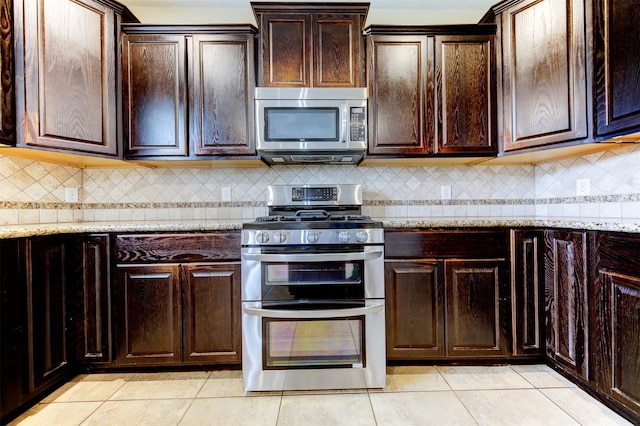 kitchen featuring tasteful backsplash, light tile patterned floors, stainless steel appliances, light stone counters, and dark brown cabinetry