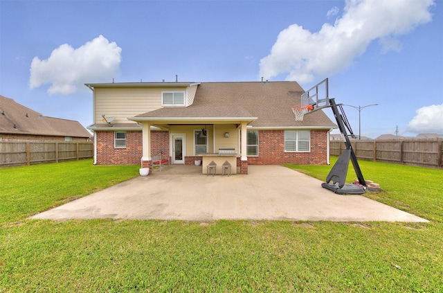 rear view of house with a patio, brick siding, a lawn, and outdoor dry bar