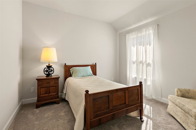 bedroom with vaulted ceiling, baseboards, and carpet floors