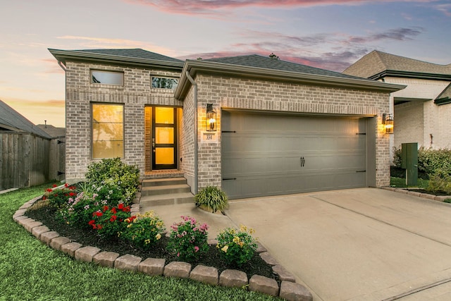 view of front of property with entry steps, fence, concrete driveway, an attached garage, and brick siding