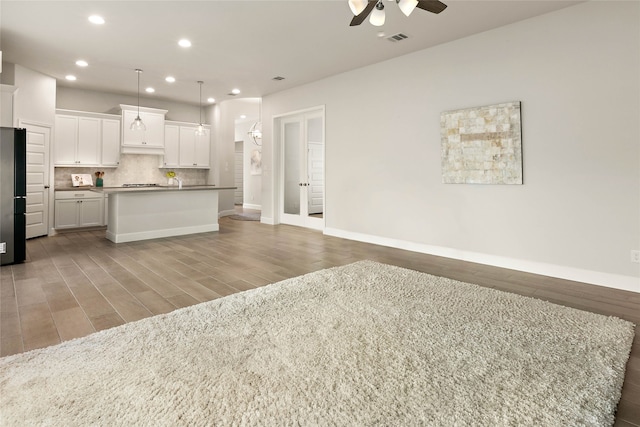 kitchen featuring visible vents, decorative backsplash, light wood-style flooring, refrigerator, and a ceiling fan