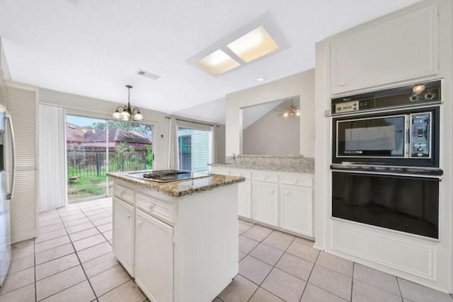 kitchen with visible vents, white cabinets, dobule oven black, a notable chandelier, and a center island