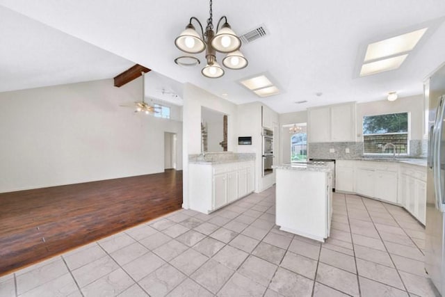 kitchen with a chandelier, visible vents, lofted ceiling with beams, and light tile patterned flooring