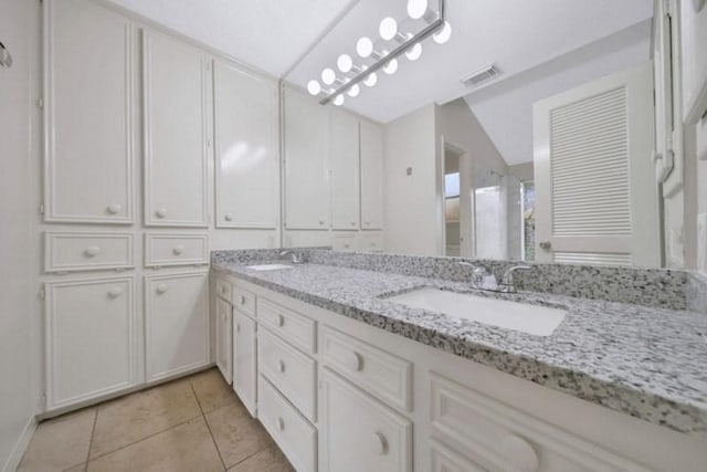 bathroom featuring tile patterned flooring, visible vents, double vanity, and a sink