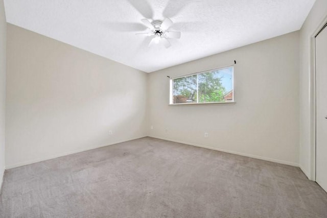 unfurnished room with a textured ceiling, ceiling fan, and carpet floors