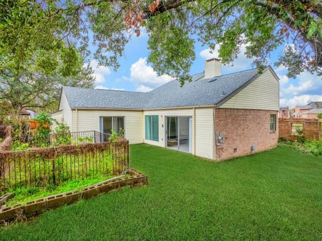 rear view of house featuring fence, a chimney, crawl space, a lawn, and brick siding