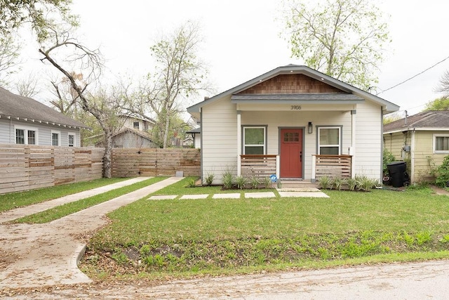 view of front of property featuring a porch, a front lawn, and fence