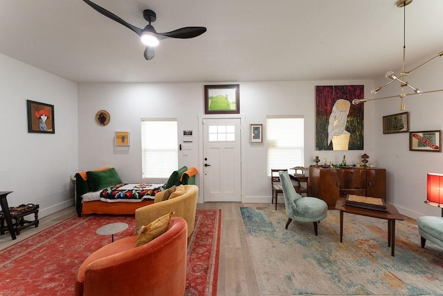 living room featuring baseboards, wood finished floors, and a ceiling fan