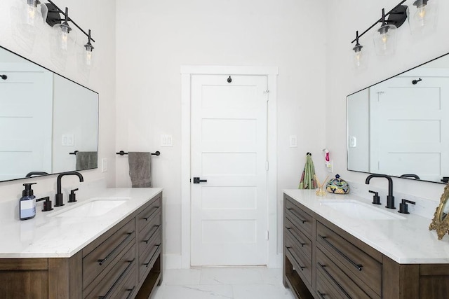 full bathroom featuring marble finish floor, two vanities, and a sink