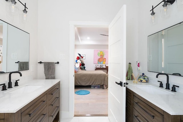 bathroom featuring a sink, connected bathroom, and two vanities