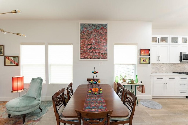 dining room with baseboards and light wood-type flooring