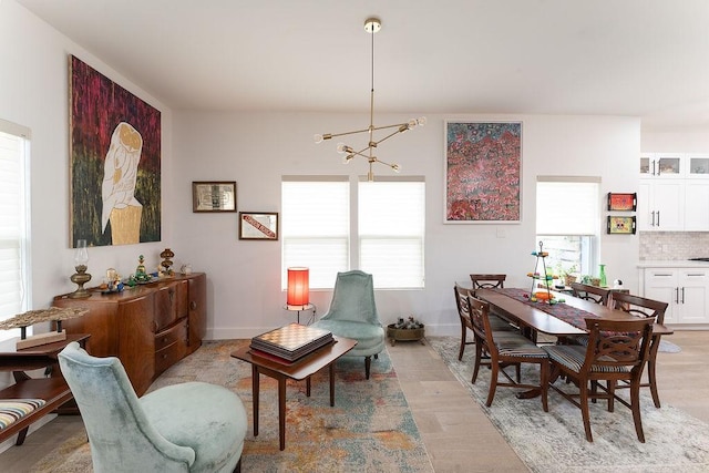 dining area with baseboards and a notable chandelier