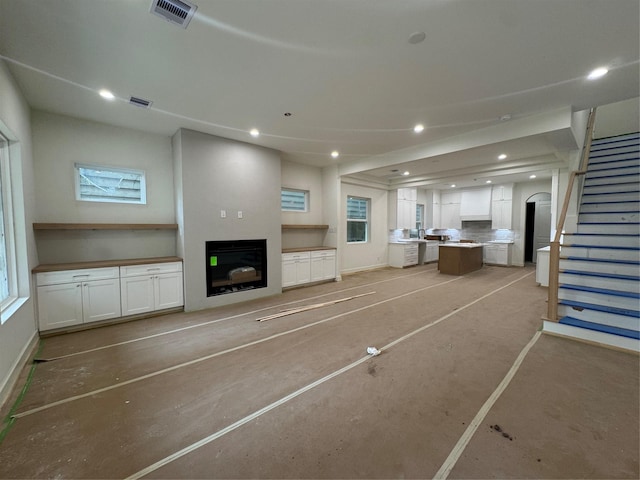 4403 Feagan, Houston, TX 77007 - unfurnished living room featuring a fireplace, stairway, recessed lighting, baseboards, and arched walkways