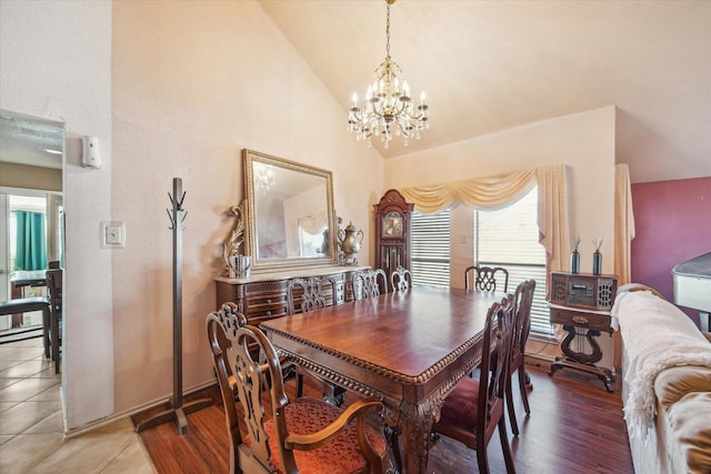 dining room featuring high vaulted ceiling, an inviting chandelier, and wood finished floors