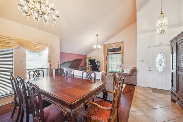 tiled dining area featuring a chandelier and lofted ceiling