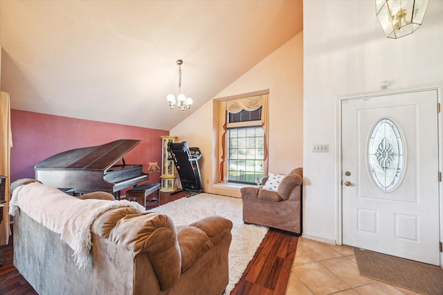 foyer entrance featuring lofted ceiling, a notable chandelier, and wood finished floors