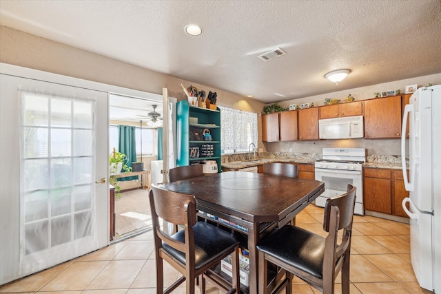 dining room with ceiling fan, visible vents, a textured ceiling, and light tile patterned flooring