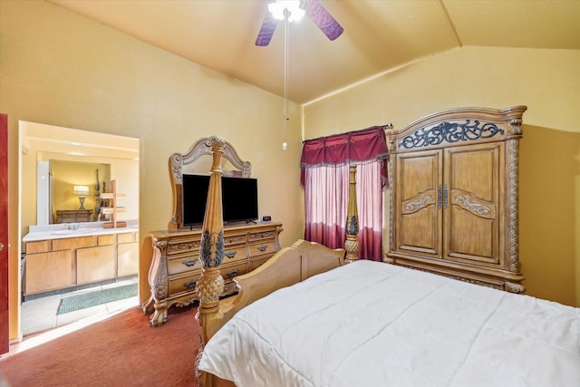 bedroom featuring carpet floors, vaulted ceiling, ensuite bathroom, a ceiling fan, and a sink