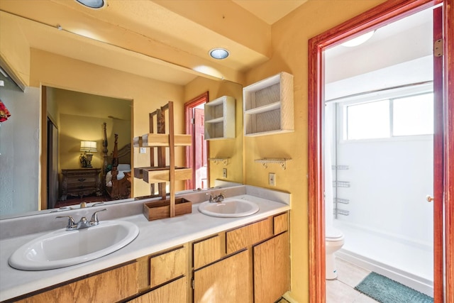 bathroom featuring a sink, toilet, double vanity, and tile patterned floors