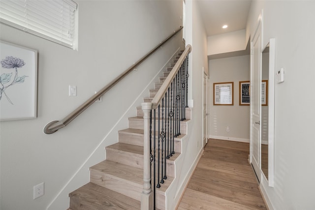 stairway featuring recessed lighting, baseboards, and wood finished floors