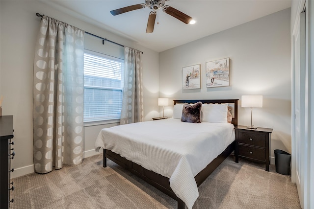 bedroom featuring light carpet, ceiling fan, and baseboards