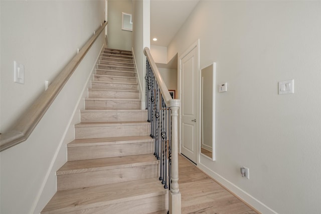 staircase featuring recessed lighting, wood finished floors, and baseboards