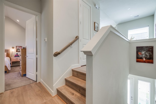 stairway featuring visible vents, baseboards, and wood finished floors