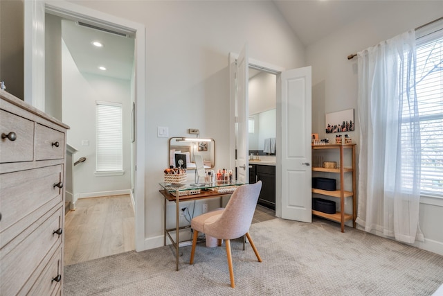 dining area featuring light carpet, a healthy amount of sunlight, baseboards, and lofted ceiling