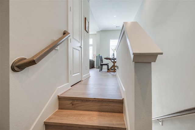 stairway with wood finished floors and baseboards