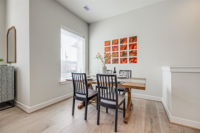 dining room with baseboards, visible vents, and light wood finished floors