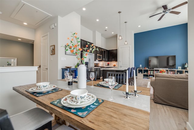 dining space featuring recessed lighting, attic access, light wood-style flooring, and ceiling fan