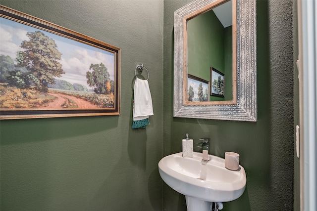 bathroom featuring a textured wall and a sink