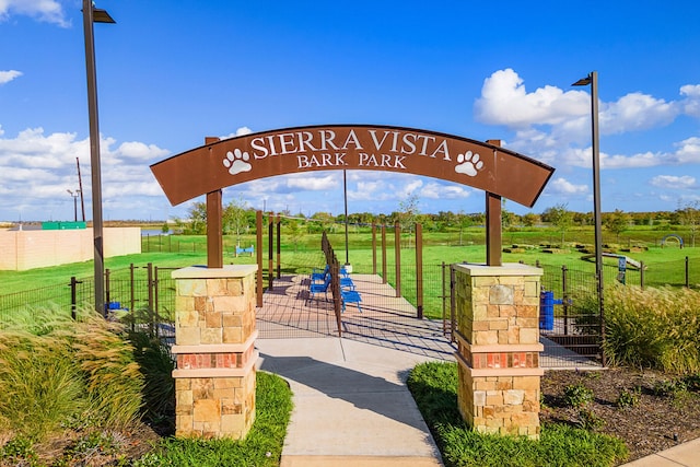 view of property's community featuring a lawn and fence