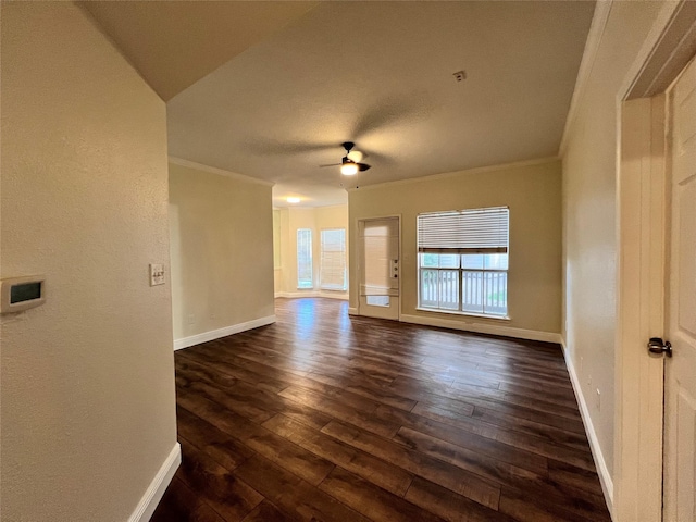 unfurnished living room with baseboards, dark wood-type flooring, and crown molding