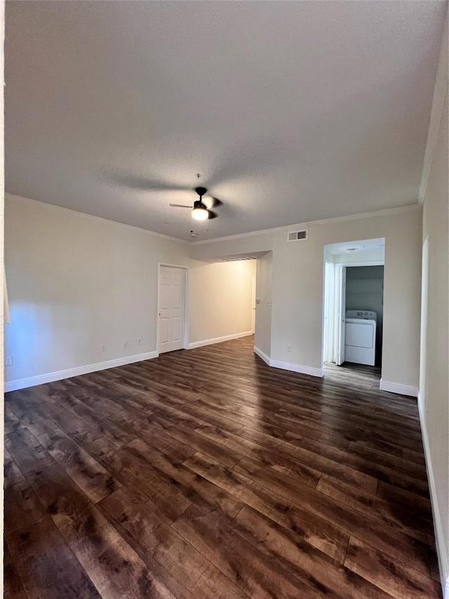 spare room with visible vents, dark wood-type flooring, baseboards, washer / clothes dryer, and a ceiling fan