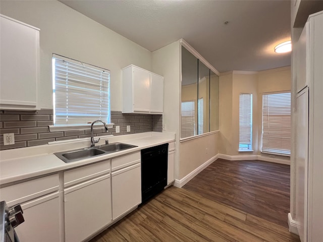 kitchen with a sink, black dishwasher, dark wood finished floors, white cabinets, and light countertops