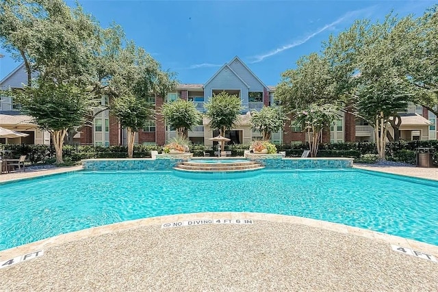 community pool featuring a hot tub