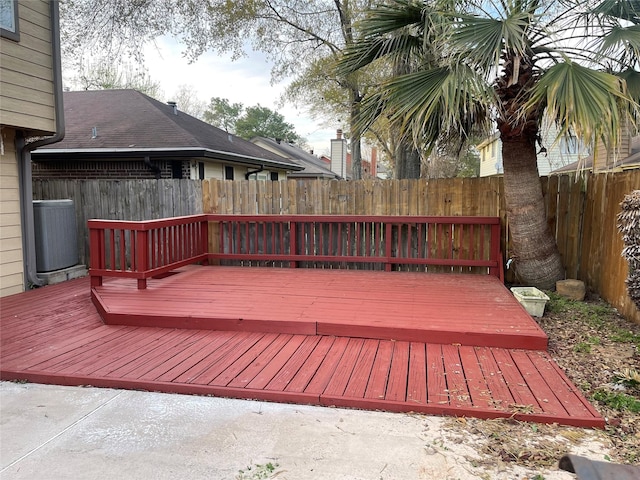 wooden terrace with central air condition unit and a fenced backyard