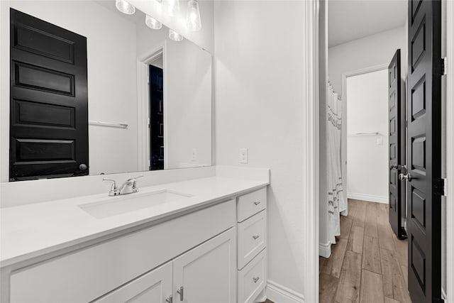 bathroom with vanity, baseboards, and wood finished floors