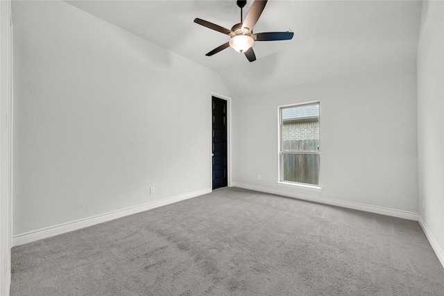 carpeted spare room featuring baseboards, ceiling fan, and vaulted ceiling