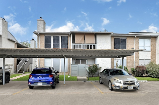 view of building exterior featuring covered parking and stairway