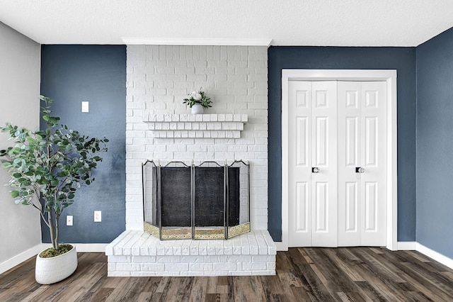 interior details with a fireplace, wood finished floors, baseboards, and a textured ceiling